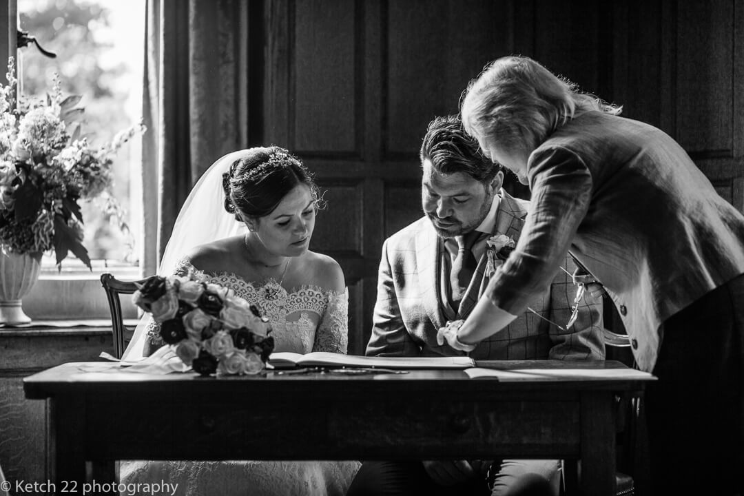 Bride and groom signing registrar at Whitney Court