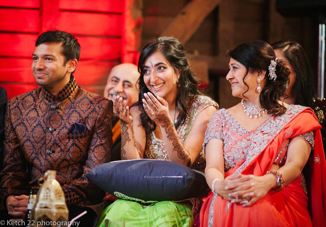Bride groom and Mum watching dancers at Indian wedding in London
