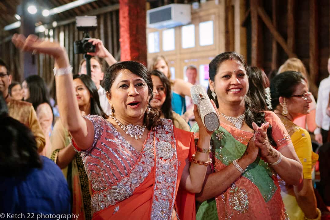 Mothers in traditional hindu costume cheering at indian henna night