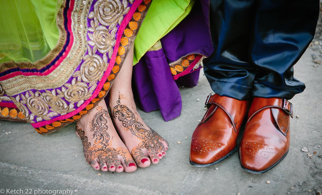 Bride painted feet and grooms red leather shoes at hindu wedding 