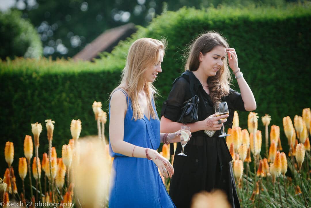 Wedding guests walking through garden with yellow flowers