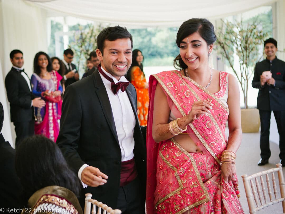 groom in tuxedo and bride in pink dress at Indian wedding
