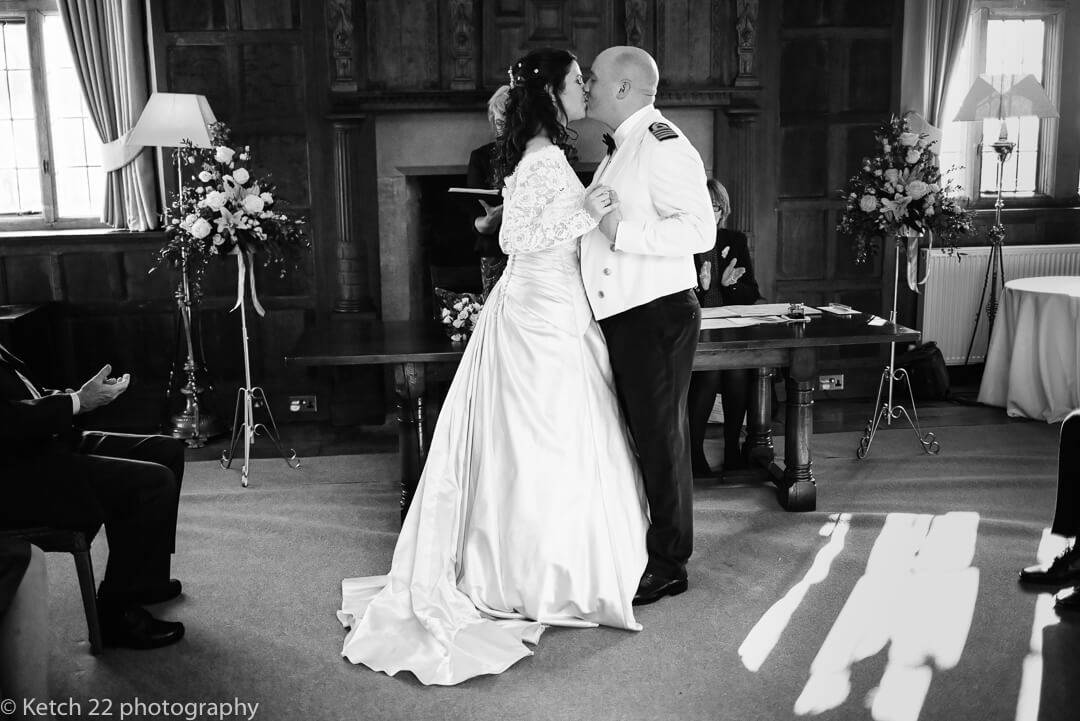 Candid wedding photo of bride and groom kissing at wedding ceremony