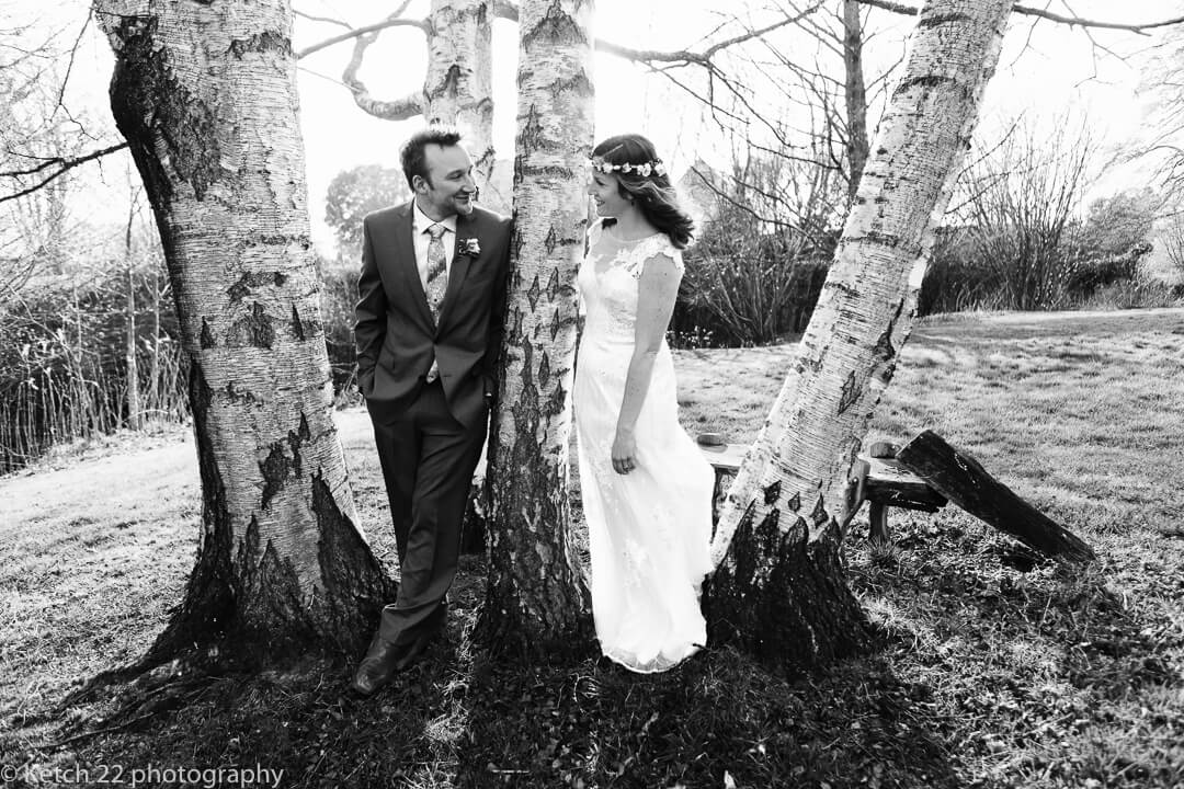 Bride and groom leaning on birch tree at Spring wedding in Herefordshire