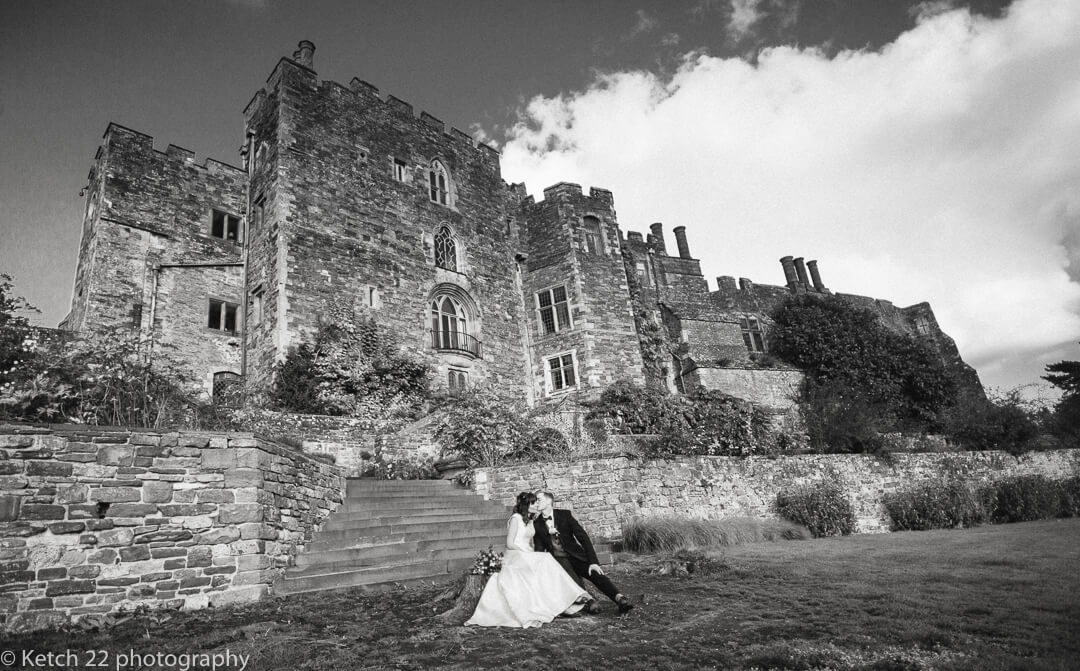 Bride and groom kissing in front of Berkeley castle in Gloucestershire