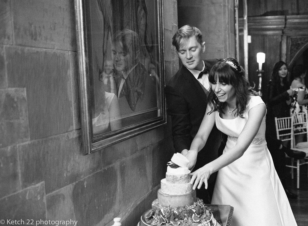 Funny quirky photo of bride and groom cutting wedding cake