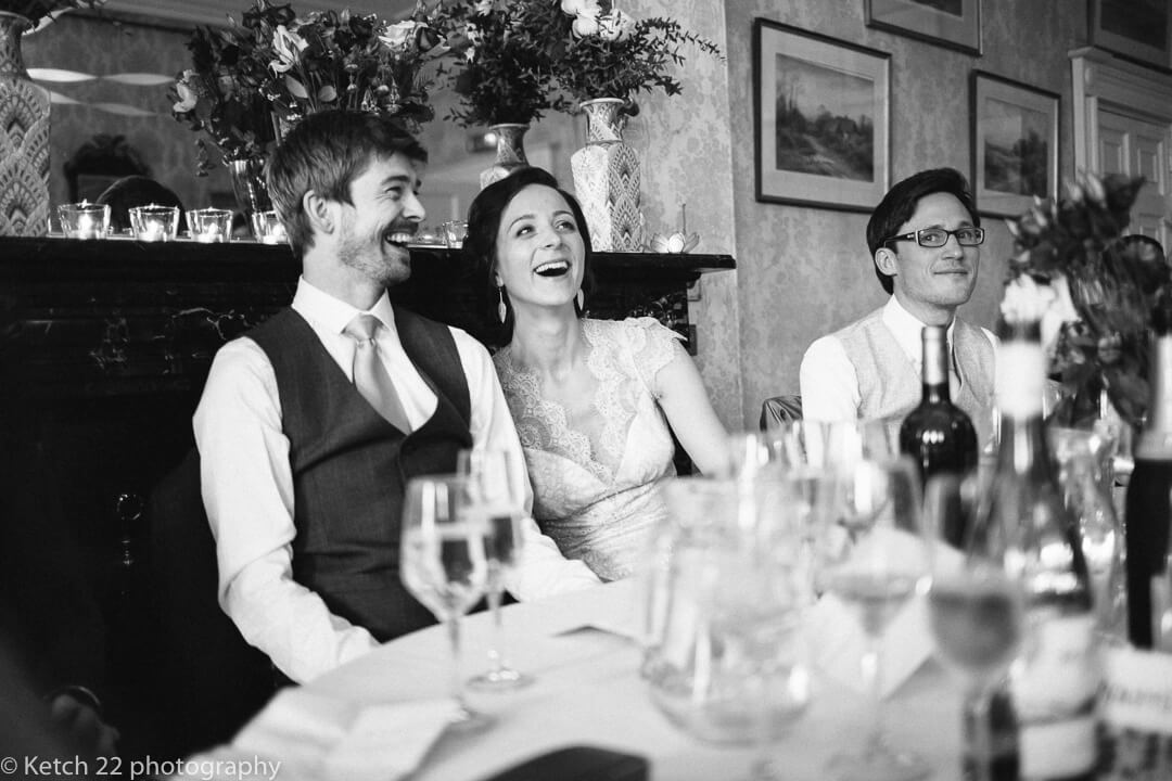Bride and groom laughing at wedding speeches in Herefordshire