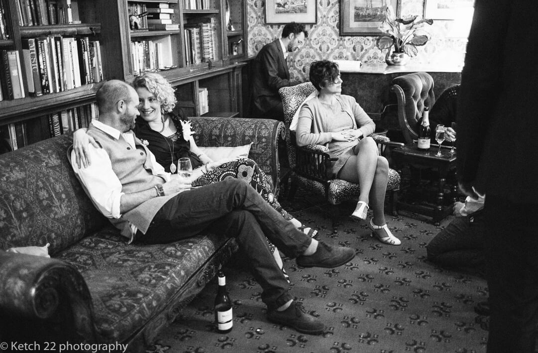 Natural wedding photo of guests relaxing in lounge at country House