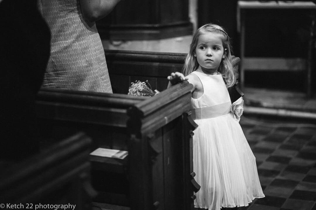 Flower girl looking up at bride as she enters church at Upper Court wedding