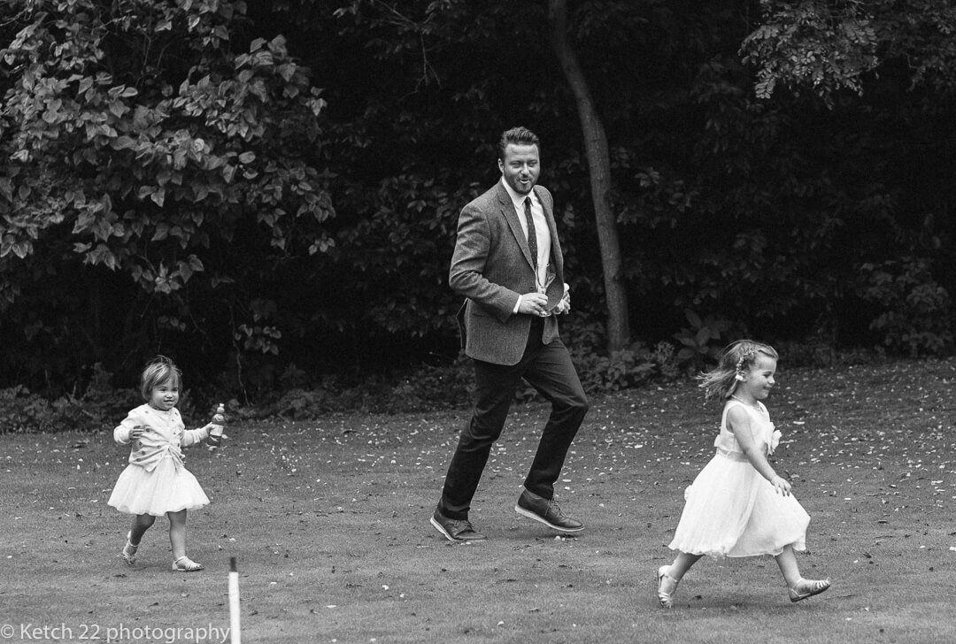 Father running wth his kids at Gloucestershire wedding