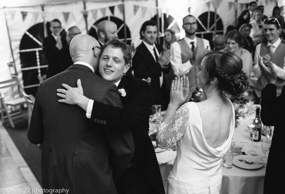 Groom hugging best man after speech at Gloucestershire wedding