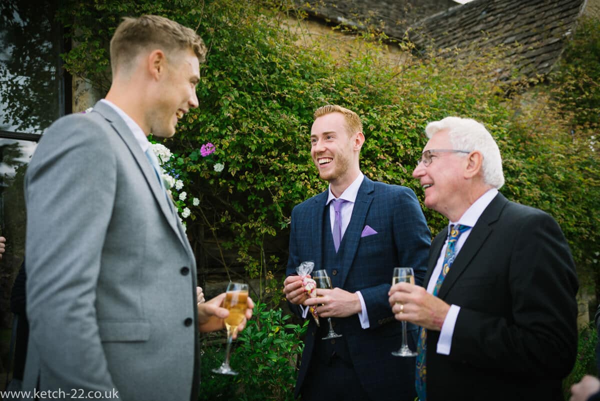 Wedding guests enjoy a drink and a chat in the garden