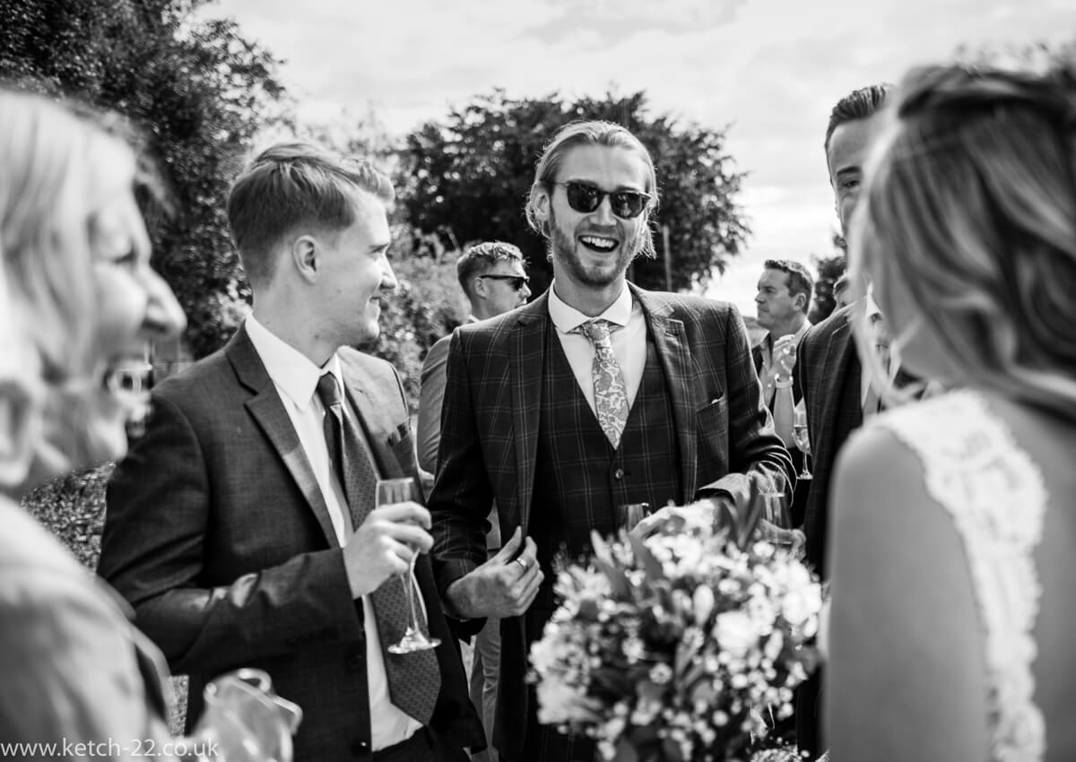 Groomsmen laughing at wedding drinks reception