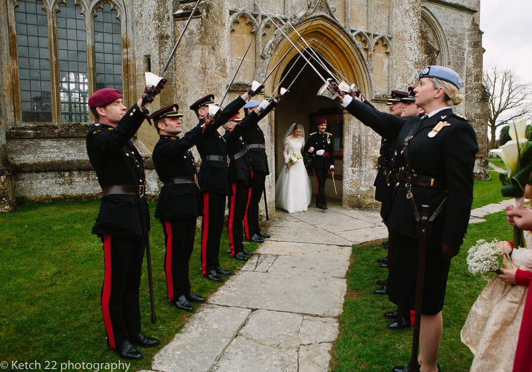 Bride and groom saluted with swords at army wedding