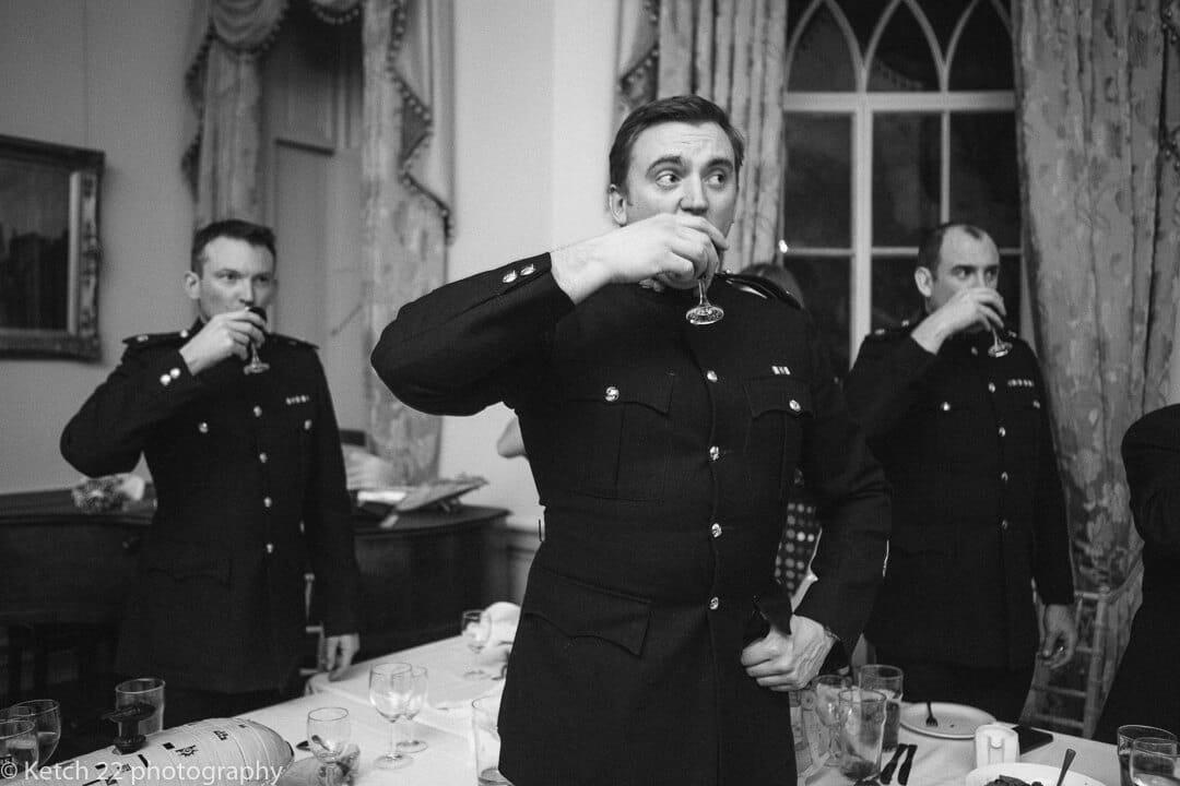 Groomsmen in army uniform toasting the bride