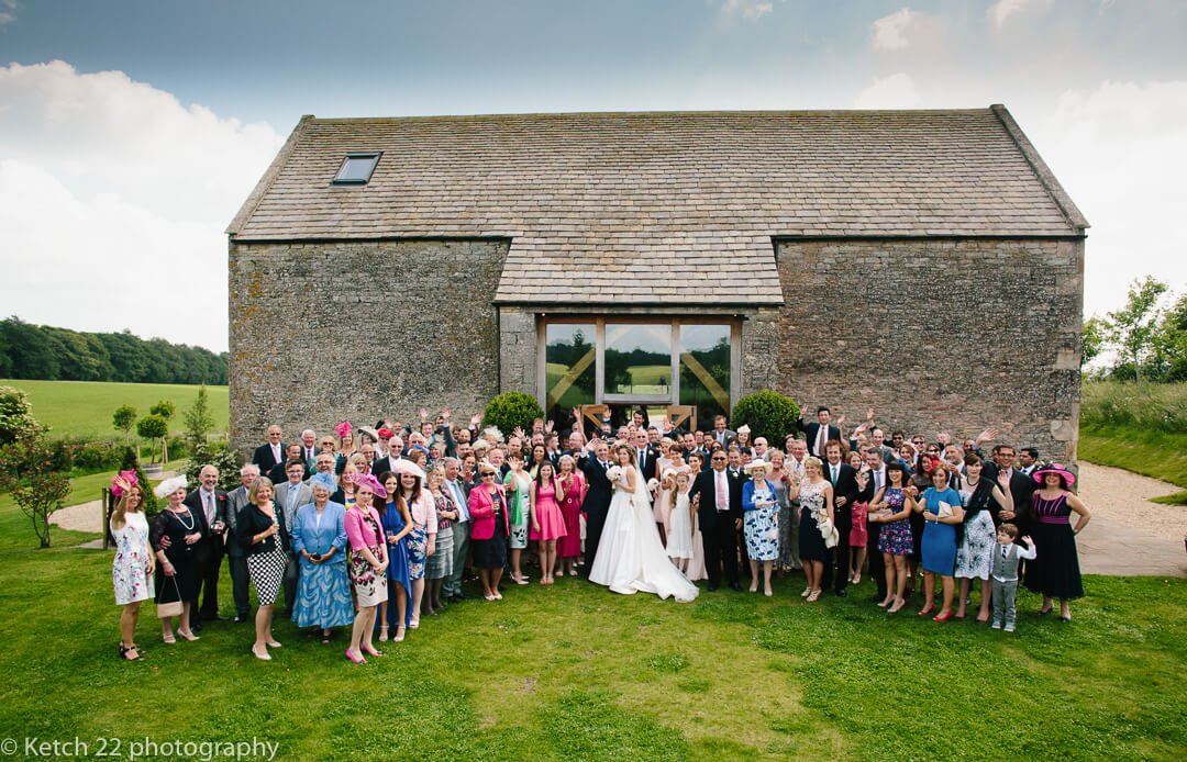 Wedding party photo in front of Cripps Stone Barn in Gloucestershire
