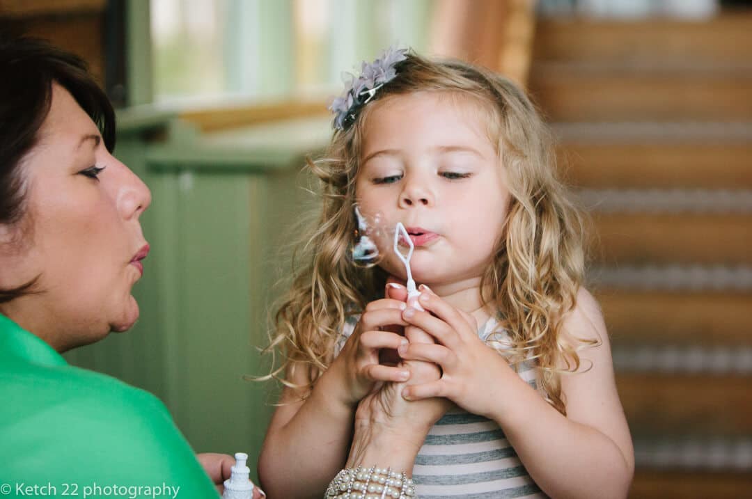 Little girl at wedding blowing bubbles