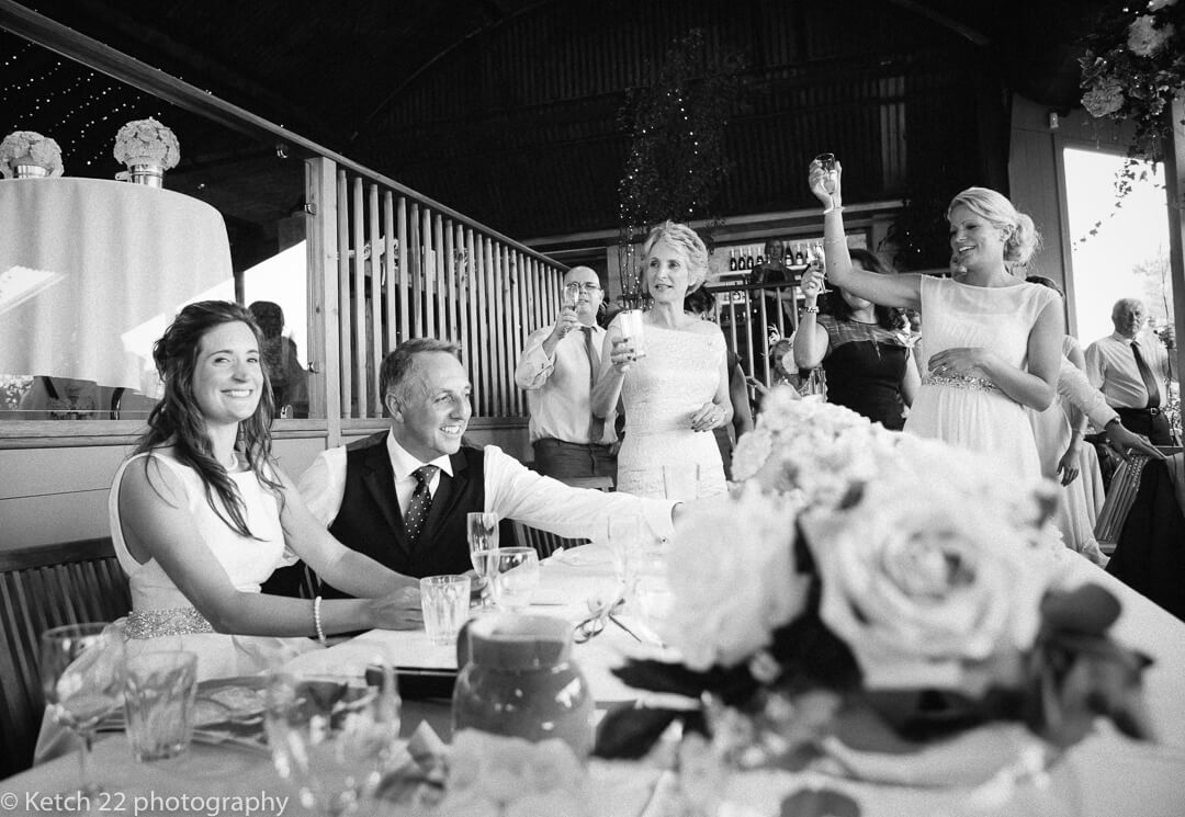 An example of weddings at Cripps Stone Barn Gloucestershire photograph of bride and groom toasting at speeches