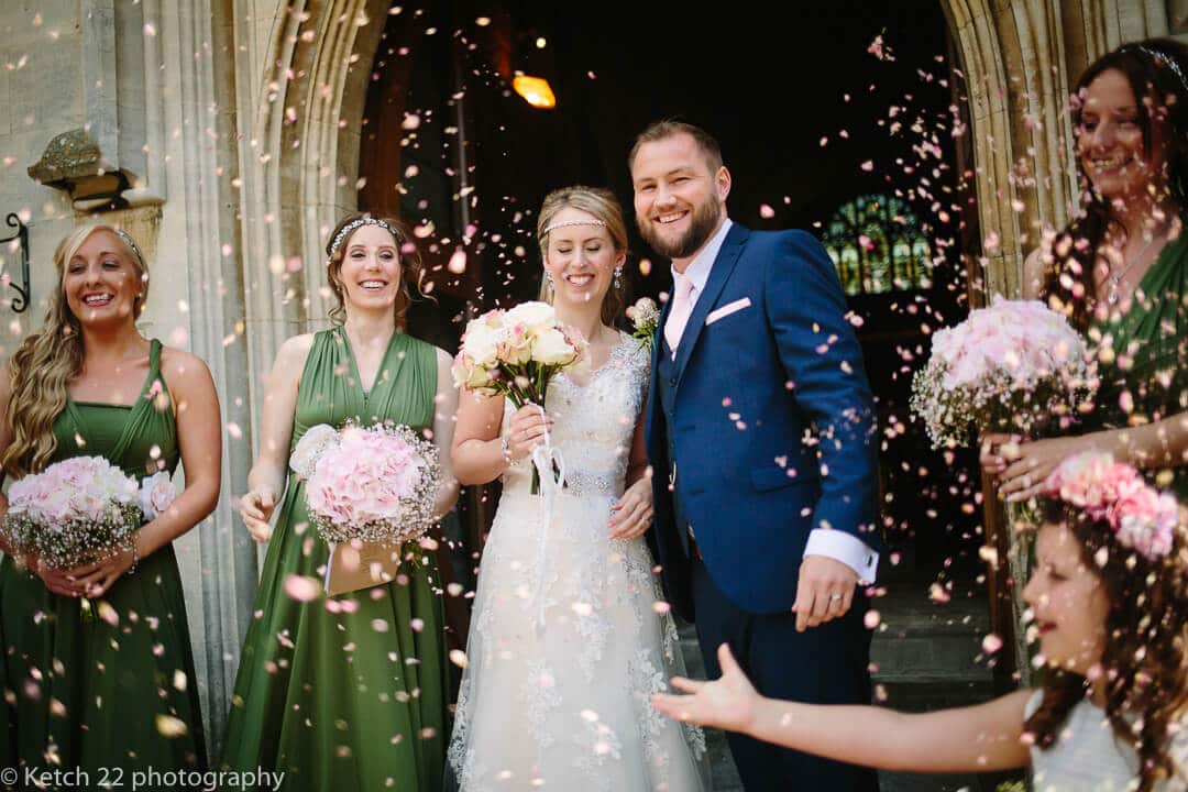 Bride and groom get showered in confetti outside church door