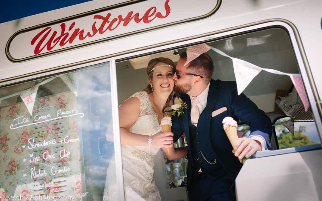 Bride and groom kissing and eating Winstones ice cream in Gloucestershire