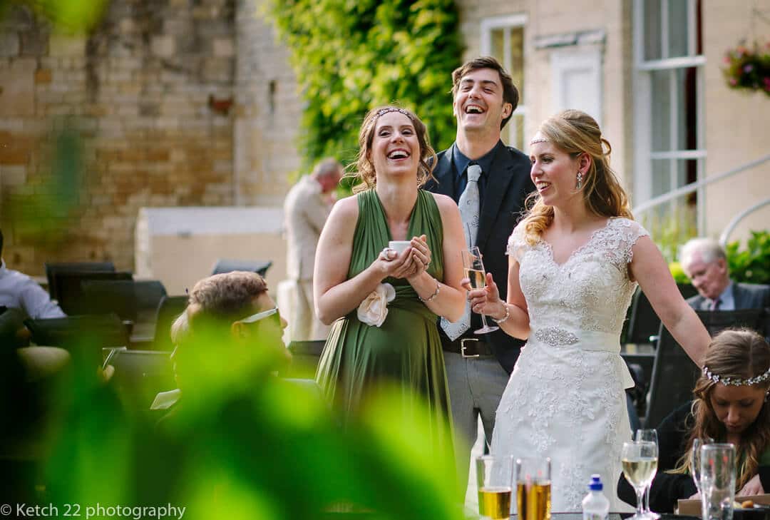 Bride laughing with wedding guests in garden at rural wedding