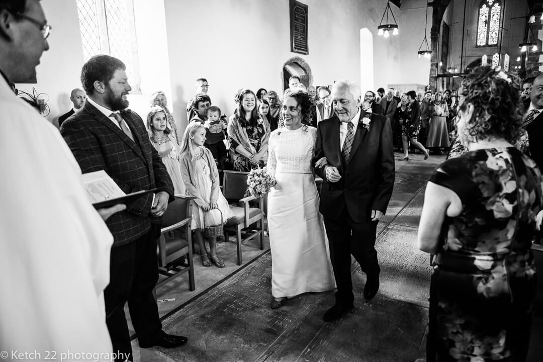 Father and bride walking down church aisle in Gloucestershire