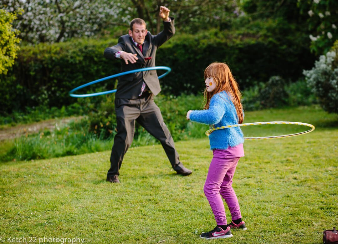 Wedding guests playing with hoola hoops at summer wedding