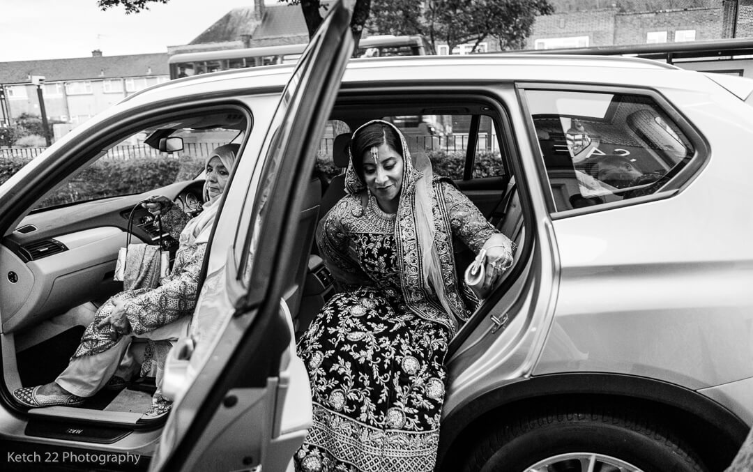 Muslim bride getting out of wedding car in Southall
