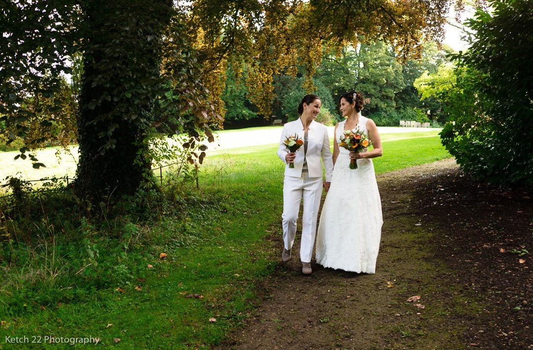 Newly weds walking in garden at Lords of the Manor