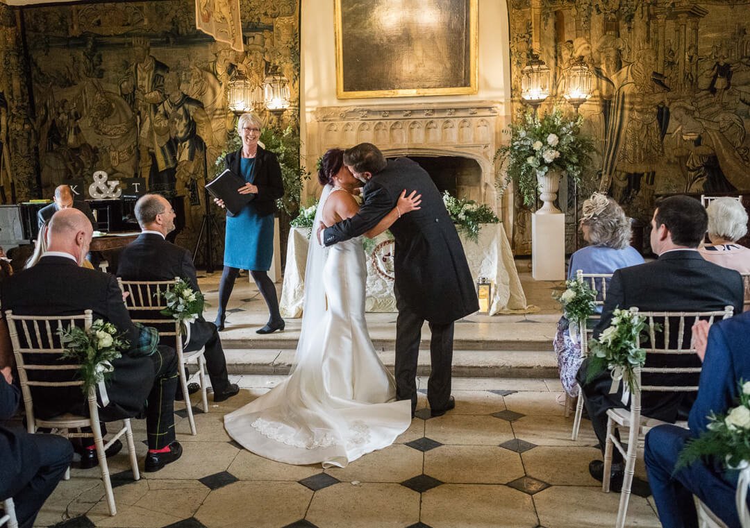 Groom kissing bride just after wedding ceremony in castle