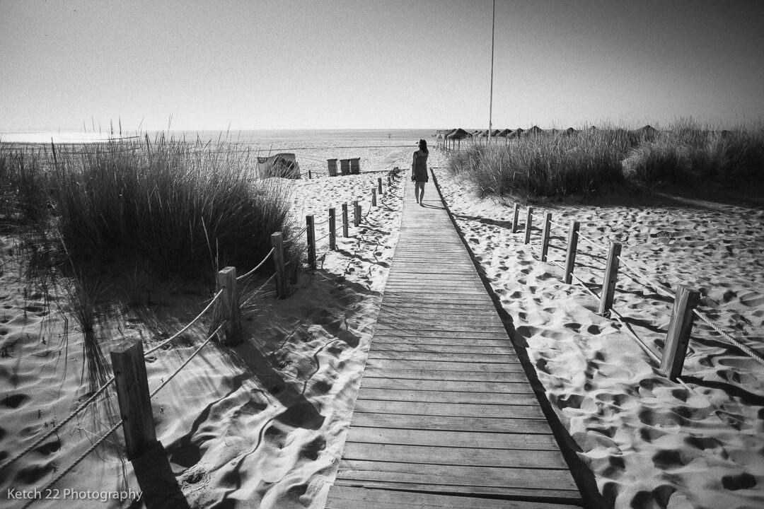 Lady on beach on wooden path