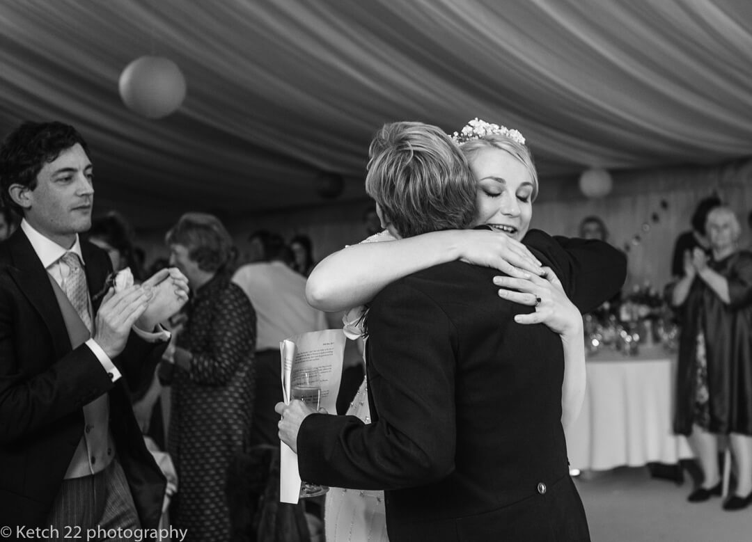 Bride hugging best man after wedding speech