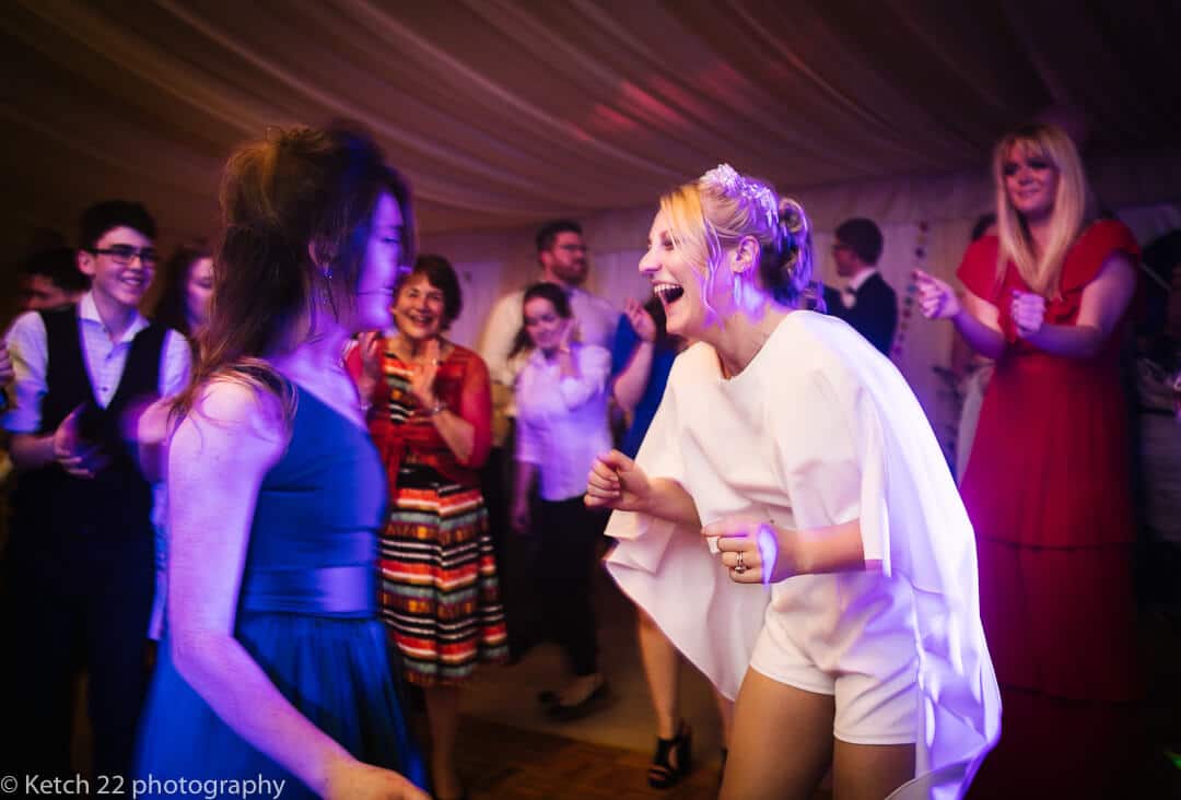 Bride in white shorts dancing at wedding reception 
