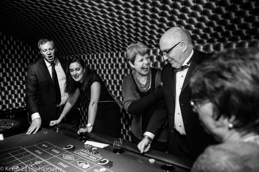 Guests laughing and enjoying casino at documentary wedding