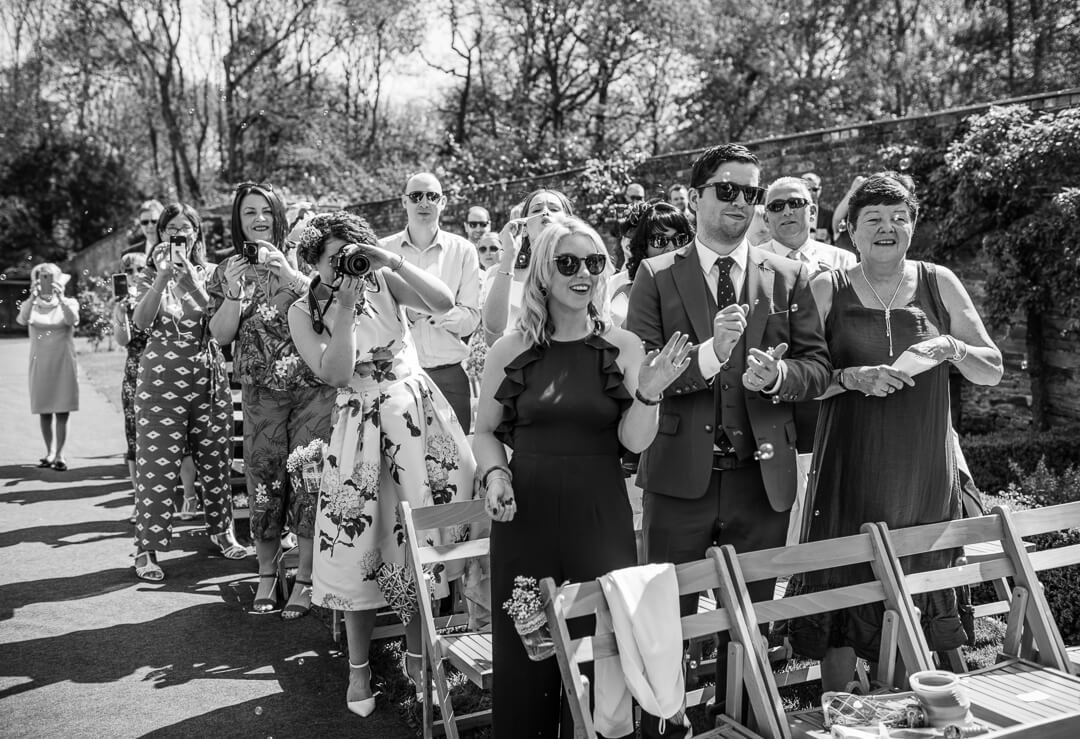 Documentary wedding photo of guests cheering at ceremony