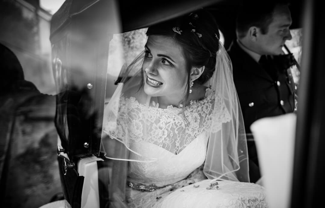 Documentary wedding photo of bride looking out of wedding car