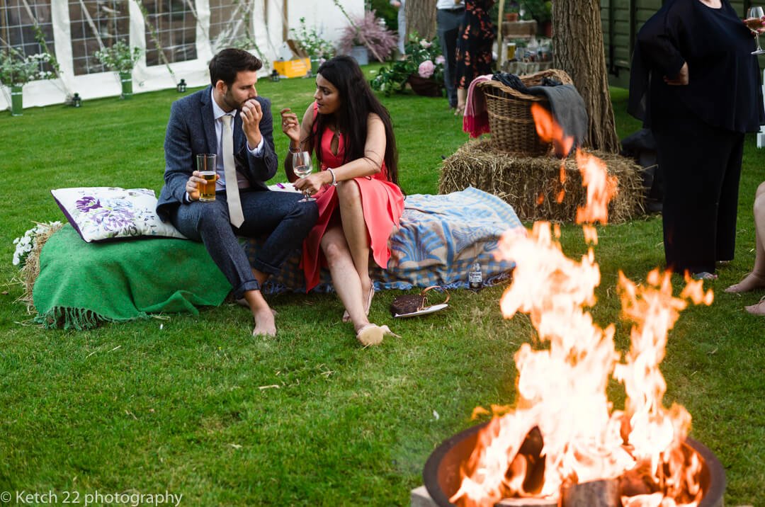 Wedding guests kick off their shoes and relax by the fire