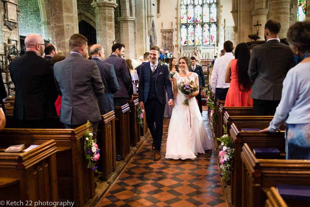 Bride and groom leaving church after Herefordshire wedding ceremony