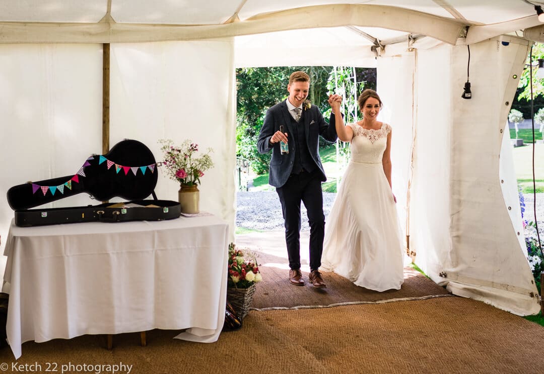 Bride and groom make an entrance at Marquee wedding