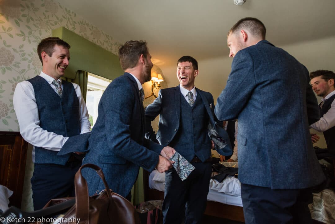 Groomsmen laughing at wedding preparations at The Lion Hotel in Herefordshire
