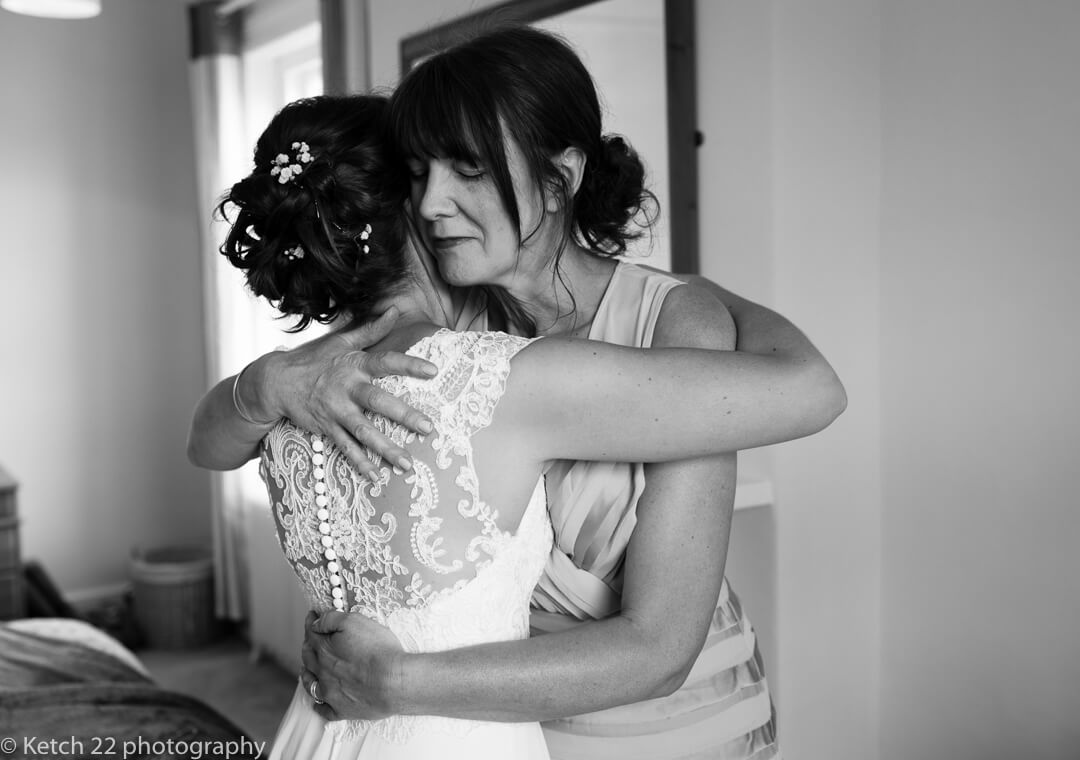 Bride hugging her mother at wedding preparations