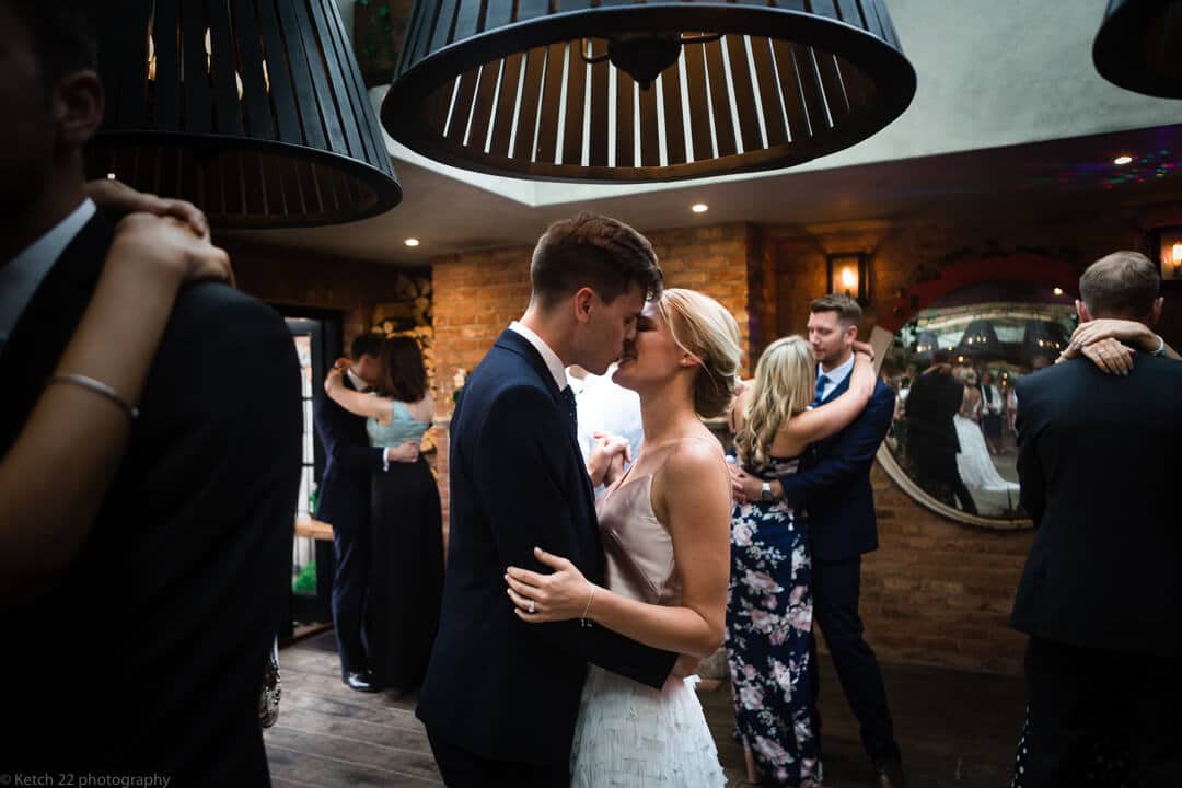 Bride and groom kissing at wedding reception