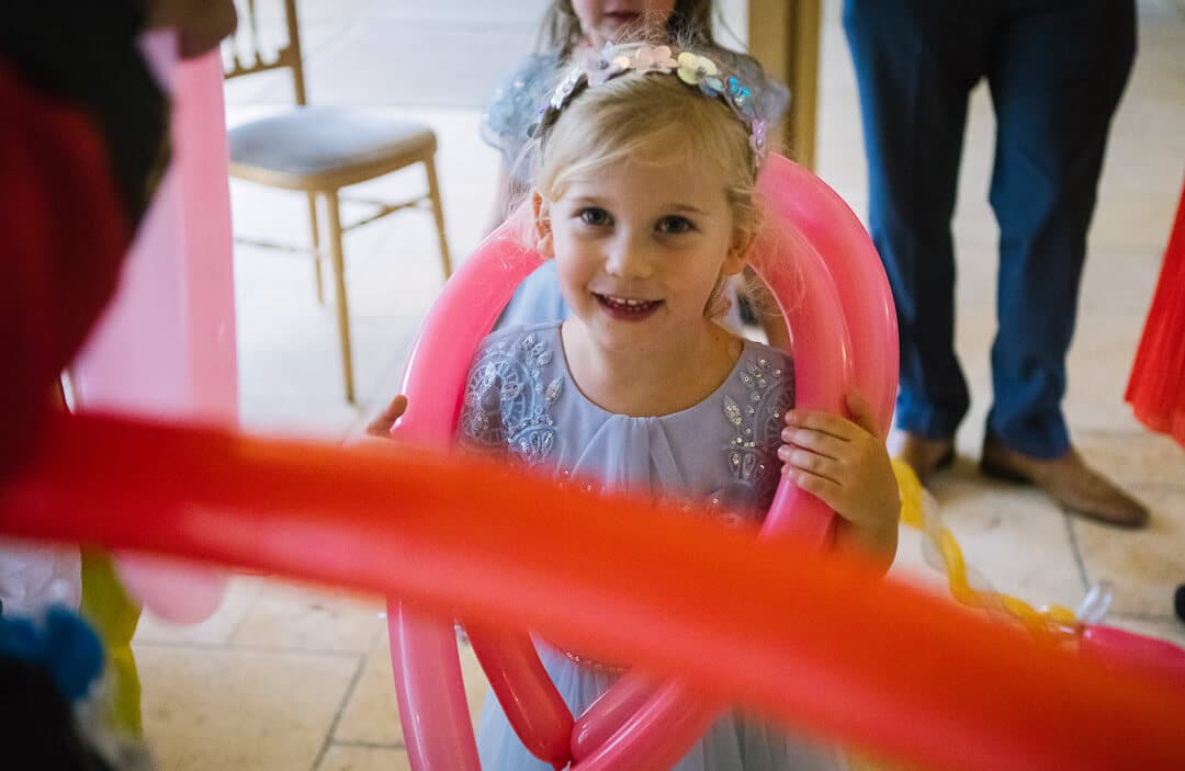 Flower girl with red balloons at wedding
