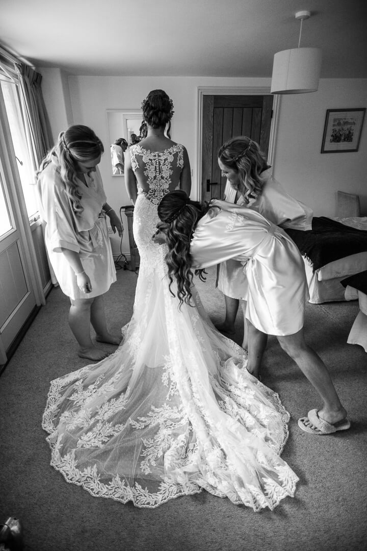 Full length view of bride putting on wedding dress