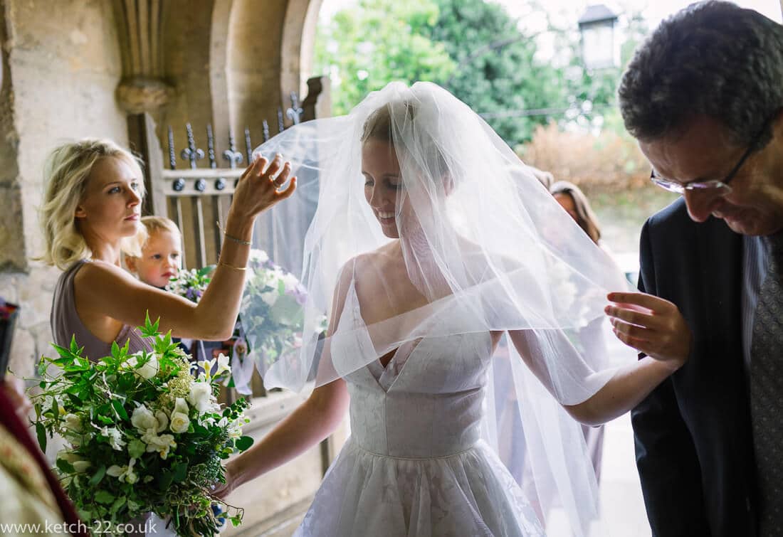 Bride having her veil adjusted - Wedding photographer Winchcombe