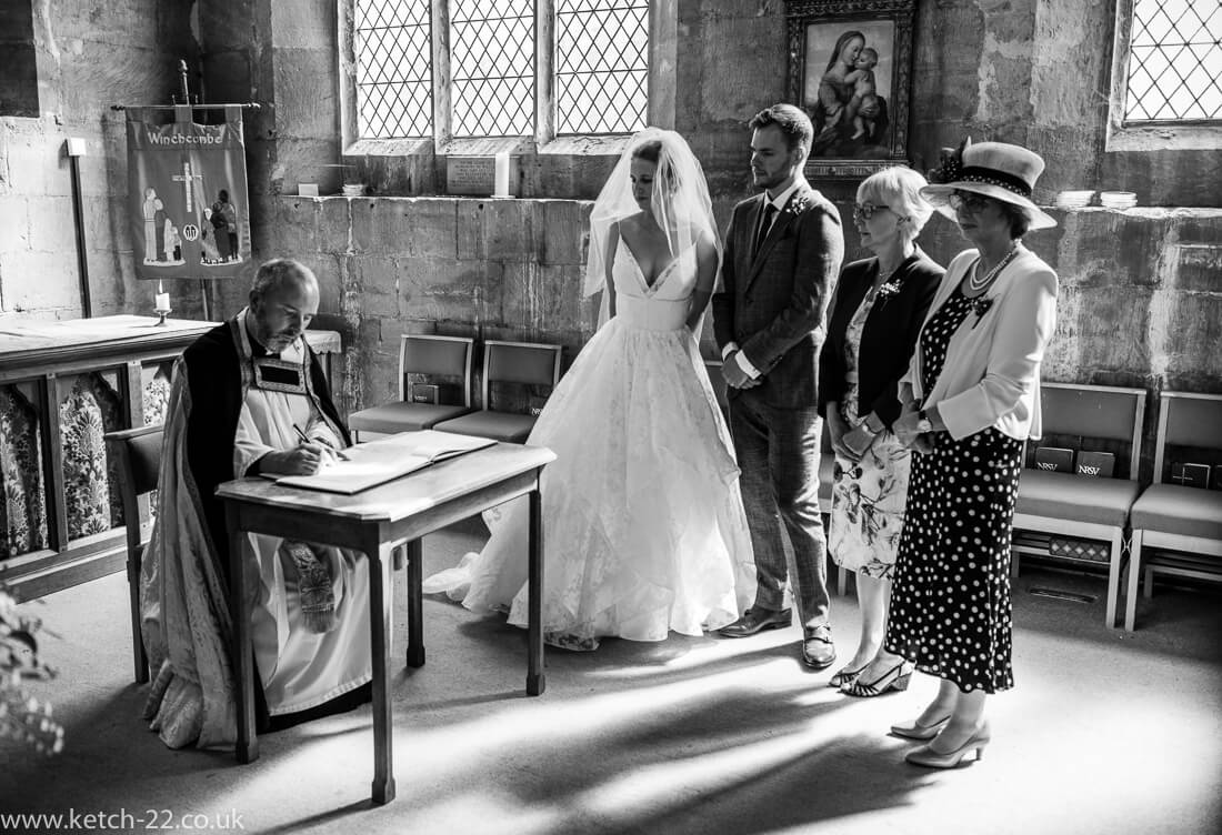 Vicar signing registrar at natural wedding