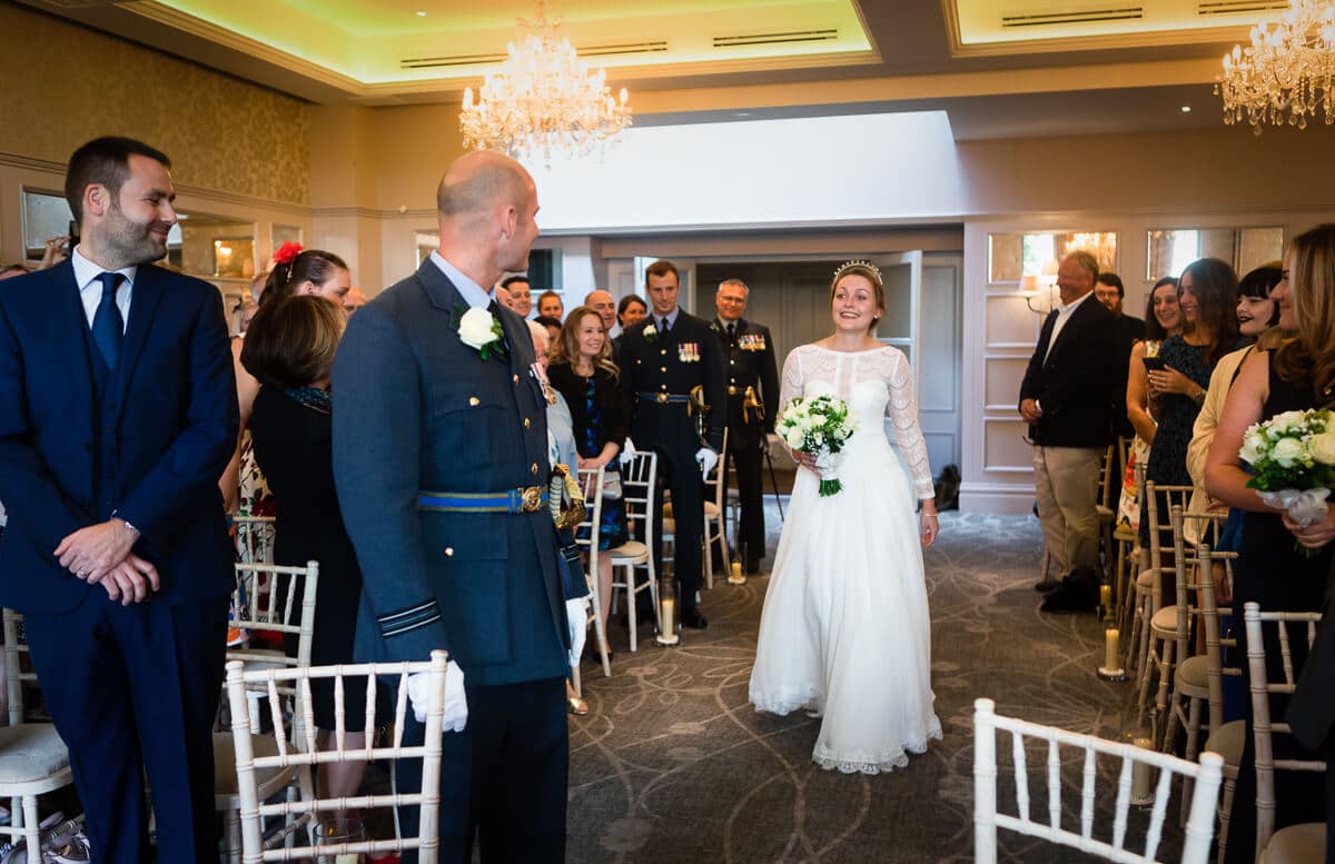 Bride takes her first look at groom in RAF uniform at De Vere Latimer Estate Wedding