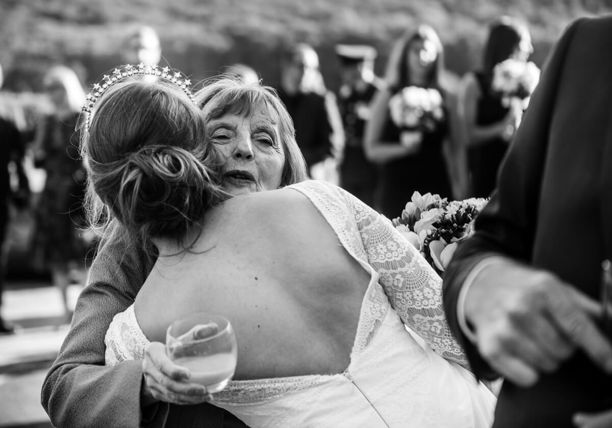 Wedding guest hugging bride