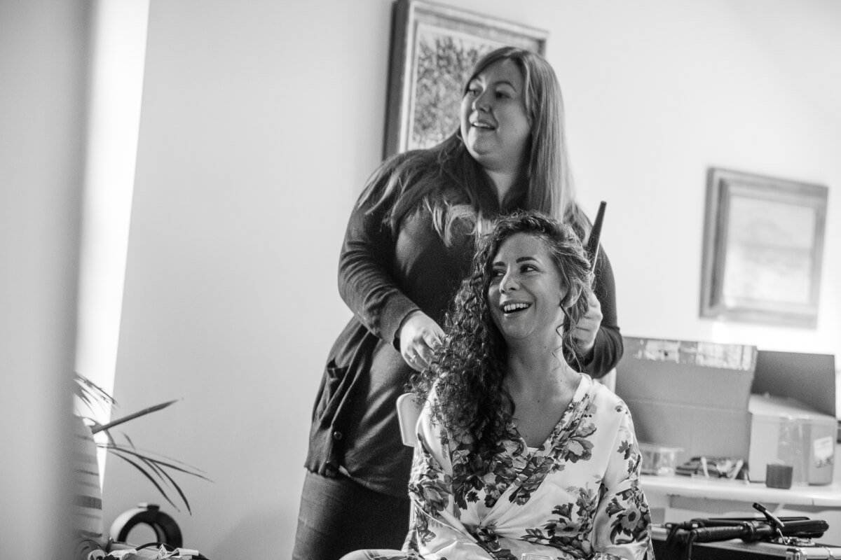 Black and white photo of bride having hair done