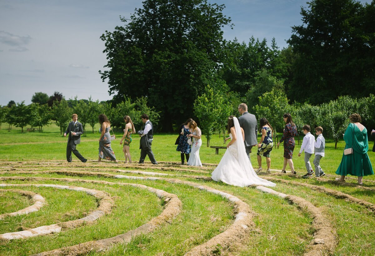 Wedding guest and couple walking around spiral circle